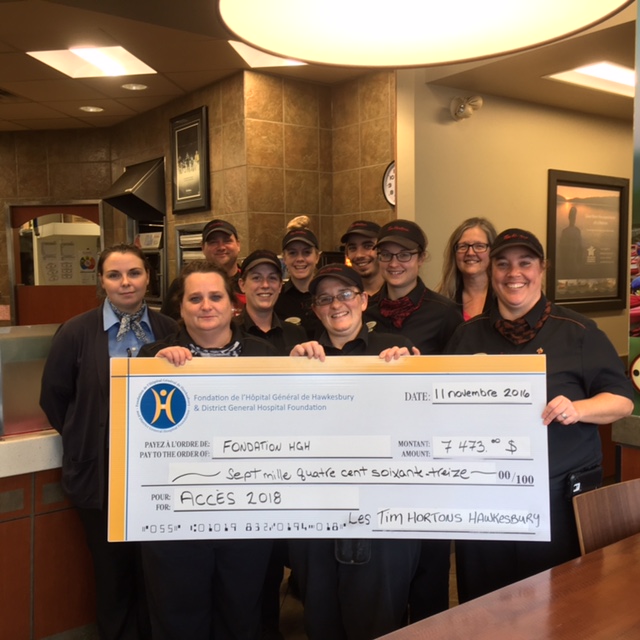 A group of Tim Hortons' employees hand a cheque for $7,473 for the Smile Cookie campaign 2016.